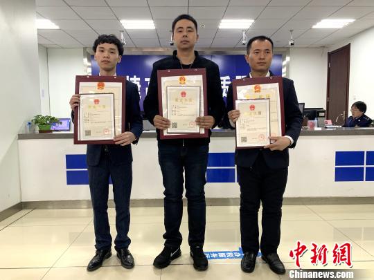 圖為首批電子商務經營者領取到網絡經營場所個體營業執照并合影?！O睿 攝