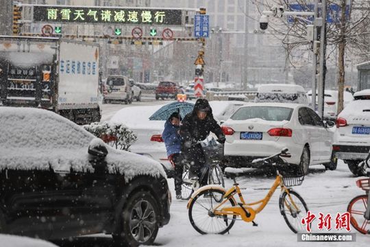 河南迎降雪天氣 民眾冒雪拎行李箱出行